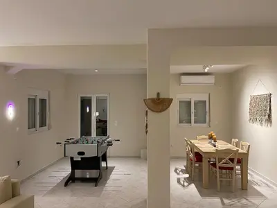 a living room with a table and a dining room at Serene Seaside Villa Raf with Unique Sunset View in Nisídhes Markéllou
