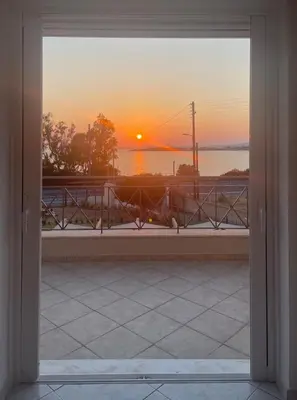 a view of a sunset through a window at Serene Seaside Villa Raf with Unique Sunset View in Nisídhes Markéllou