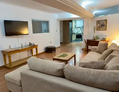 a living room with a couch and a tv at Exclusive Penthouse Apt, at Glyfada Marina & Beach in Athens