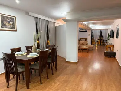 a dining room and living room with a table and chairs at Exclusive Penthouse Apt, at Glyfada Marina & Beach in Athens