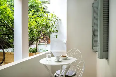 a small white table and chair on a balcony at The Athenian Veranda in Athens