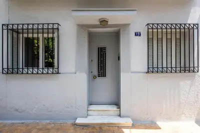a white house with a white door and two iron gates at The Athenian Veranda in Athens