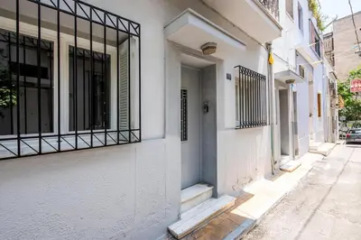 a white building with a window on a street at The Athenian Veranda in Athens