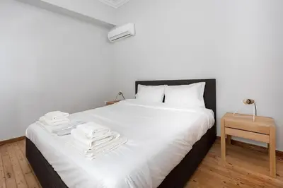 a bedroom with a white bed with towels on it at The Athenian Veranda in Athens