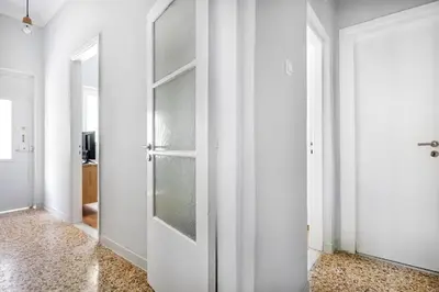 a hallway with a glass door in a white room at The Athenian Veranda in Athens
