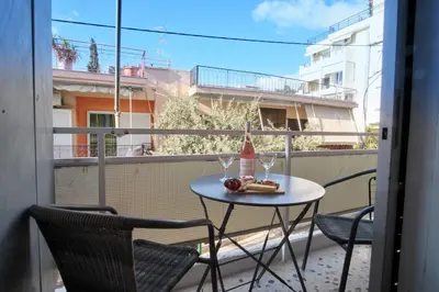 a table with two glasses and a bottle of wine on a balcony at ConEviKa in Athens