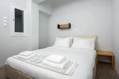 a white bed with white towels on top of it at The Athenian Veranda 2 in Athens