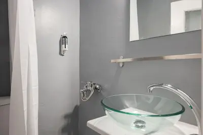 a bathroom with a glass sink and a mirror at The Athenian Veranda 2 in Athens