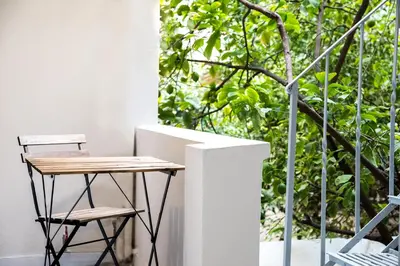a table and two chairs on a balcony with trees at The Athenian Veranda 2 in Athens