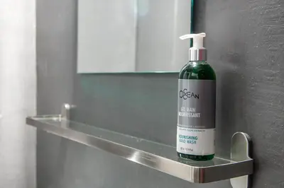 a bottle of detergent sitting on a shelf in a bathroom at The Athenian Veranda 2 in Athens
