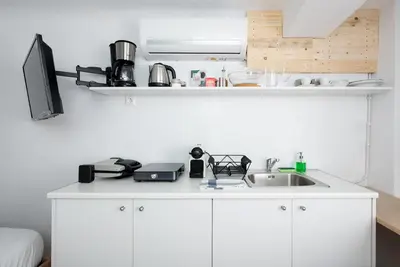 a kitchen with white cabinets and a sink at The Athenian Veranda 3 in Athens