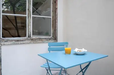 a blue table with a blue chair and a glass of orange juice at The Athenian Veranda 3 in Athens