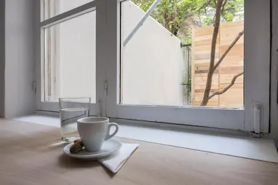 a cup of coffee and a glass of water on a table at The Athenian Veranda 3 in Athens