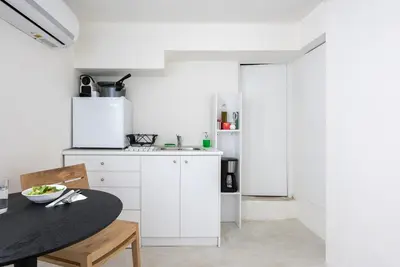 a kitchen with white cabinets and a black table at The Athenian Veranda 4 in Athens