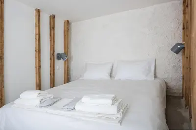 a white bed with white sheets and towels on it at The Athenian Veranda 4 in Athens