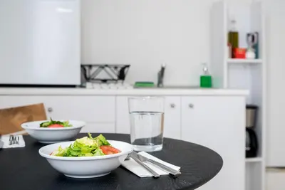 a table with two bowls of salad and a glass of water at The Athenian Veranda 4 in Athens