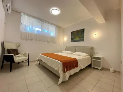 a bedroom with a bed and a chair in it at Versailles One Villa one-story suite in Metókhi