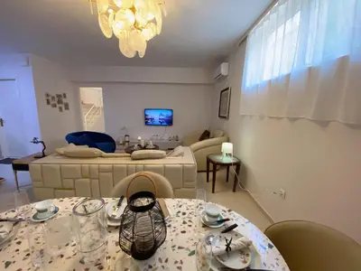 a living room with a dining table and a couch at Versailles One Villa one-story suite in Metókhi