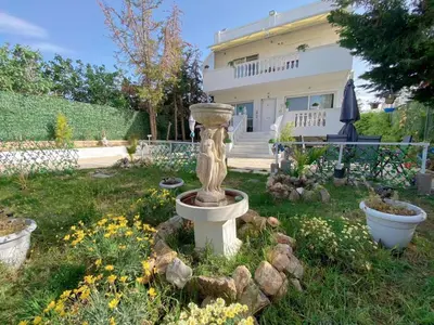 a garden with a birdbath in the yard of a house at Versailles One Villa one-story suite in Metókhi