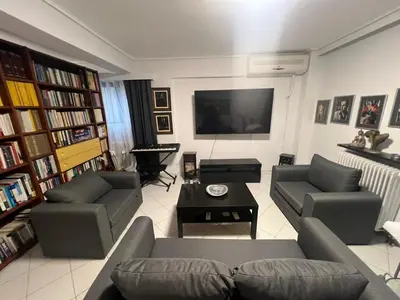 a living room with two couches and a flat screen tv at Artistic & cozy ! Just 5' to seaside in Athens