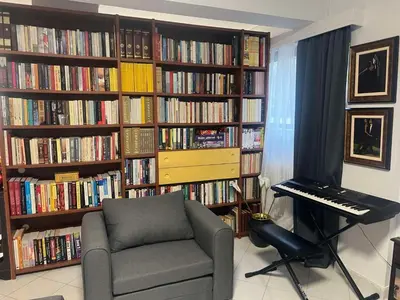 a room with a chair and a keyboard in front of a library at Artistic & cozy ! Just 5' to seaside in Athens