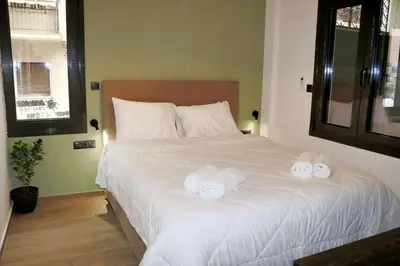 a bedroom with a large white bed with two towels at Theo Apartments in Athens Center in Athens
