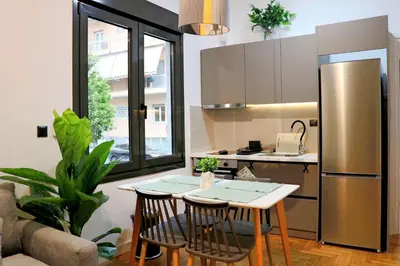 a kitchen with a table and a stainless steel refrigerator at Theo Apartments in Athens Center in Athens
