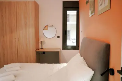 a bedroom with a bed and a window and a mirror at Theo Apartments in Athens Center in Athens