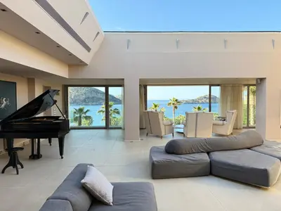 a living room with a couch and a piano at Blue Angel Villa Luxury Seafront Estate in Porto Rafti