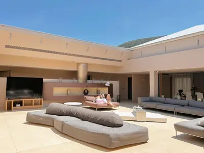 a large living room with a woman laying on a couch at Blue Angel Villa Luxury Seafront Estate in Porto Rafti