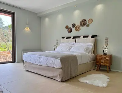a bedroom with a large bed and a window at Blue Angel Villa Luxury Seafront Estate in Porto Rafti