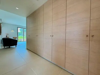 a large wall of wooden cabinets in a living room at Blue Angel Villa Luxury Seafront Estate in Porto Rafti