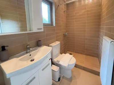 a bathroom with a white sink and a toilet at Blue Angel Villa Luxury Seafront Estate in Porto Rafti