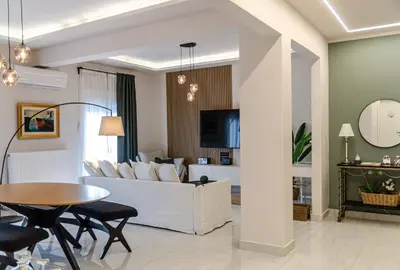 a living room with a white couch and a table at Green apartment in Piraeus