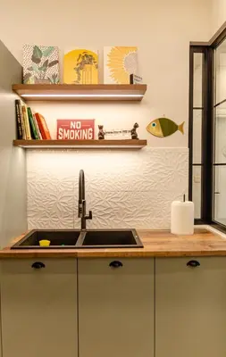 a kitchen sink with a no smoking sign on the wall at Green apartment in Piraeus