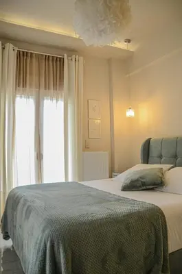 a bedroom with a bed and a large window at Green apartment in Piraeus