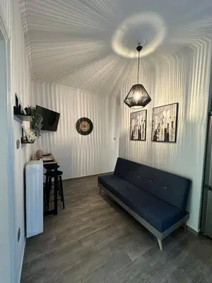 a living room with a blue couch and a table at Kamara in Athens