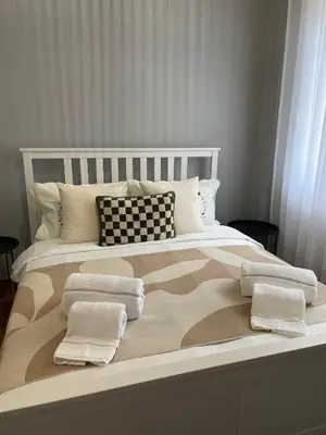 a large bed with two pillows and towels on it at my HOME in Athens