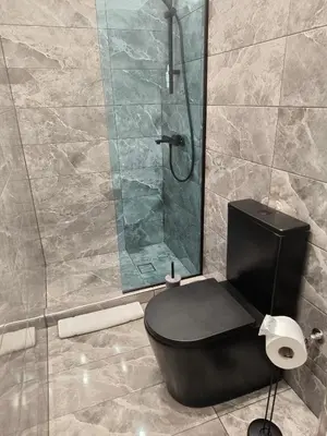 a bathroom with a black toilet and a shower at my HOME in Athens
