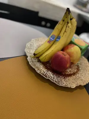 a plate of fruit with bananas and apples on a table at my HOME in Athens