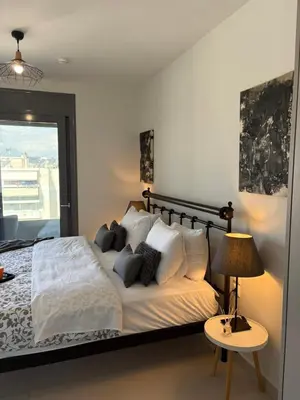 a bedroom with a bed with white sheets and pillows at Kallitheas Maison with Shared Pool in Athens