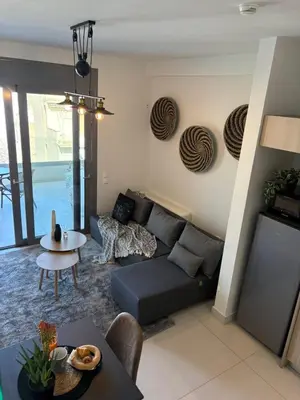 a living room with a couch and a table at Kallitheas Maison with Shared Pool in Athens