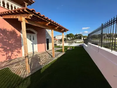 a patio with a wooden pergola next to a building at Villa Isidora Luxe in Kalívia Thorikoú