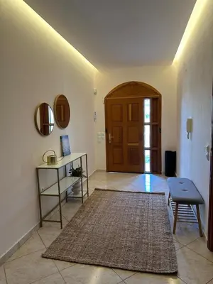 a living room with a table and a door at Villa Isidora Luxe in Kalívia Thorikoú