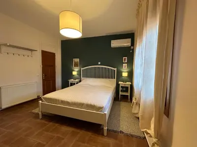 a bedroom with a bed and a green wall at Villa Isidora Luxe in Kalívia Thorikoú