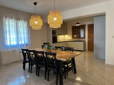 a kitchen and dining room with a wooden table and chairs at Villa Isidora Luxe in Kalívia Thorikoú
