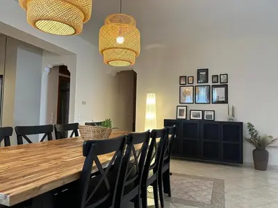 a dining room with a wooden table and black chairs at Villa Isidora Luxe in Kalívia Thorikoú