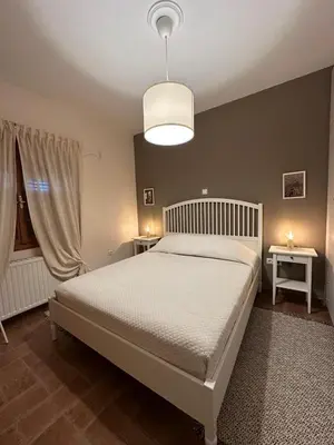 a bedroom with a white bed and two tables at Villa Isidora Luxe in Kalívia Thorikoú