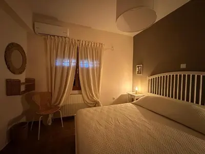 a bedroom with a bed and a window with curtains at Villa Isidora Luxe in Kalívia Thorikoú