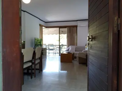 a living room with a couch and a table with chairs at 2BD apartment with large balcony near the sea!! in Athens
